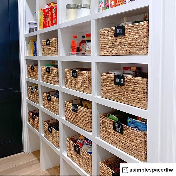 an organized pantry with baskets and food items on the shelves in front of it is shown