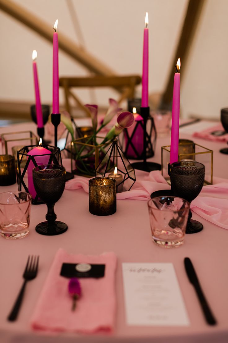 a table topped with pink napkins and candles