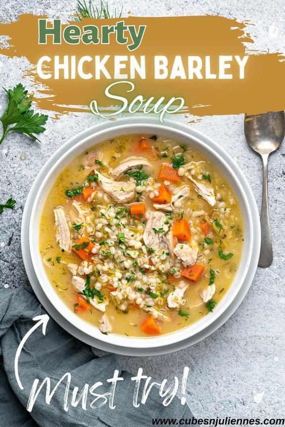 a bowl of chicken barley soup with carrots, parsley and parsley on the side