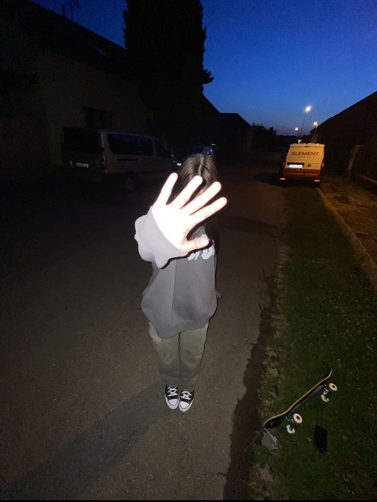 a person standing in the street with their hand up