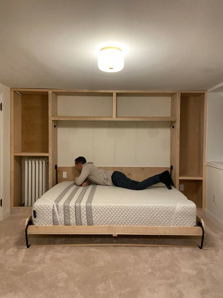 a man laying on top of a bed in a bedroom