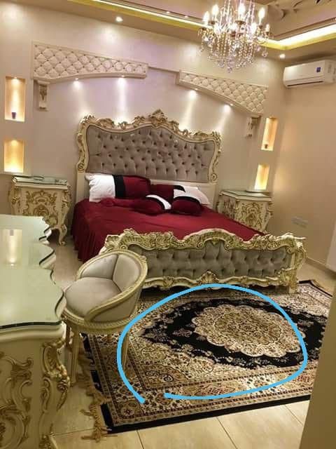 a bedroom with a bed, chair and chandelier in the middle of it