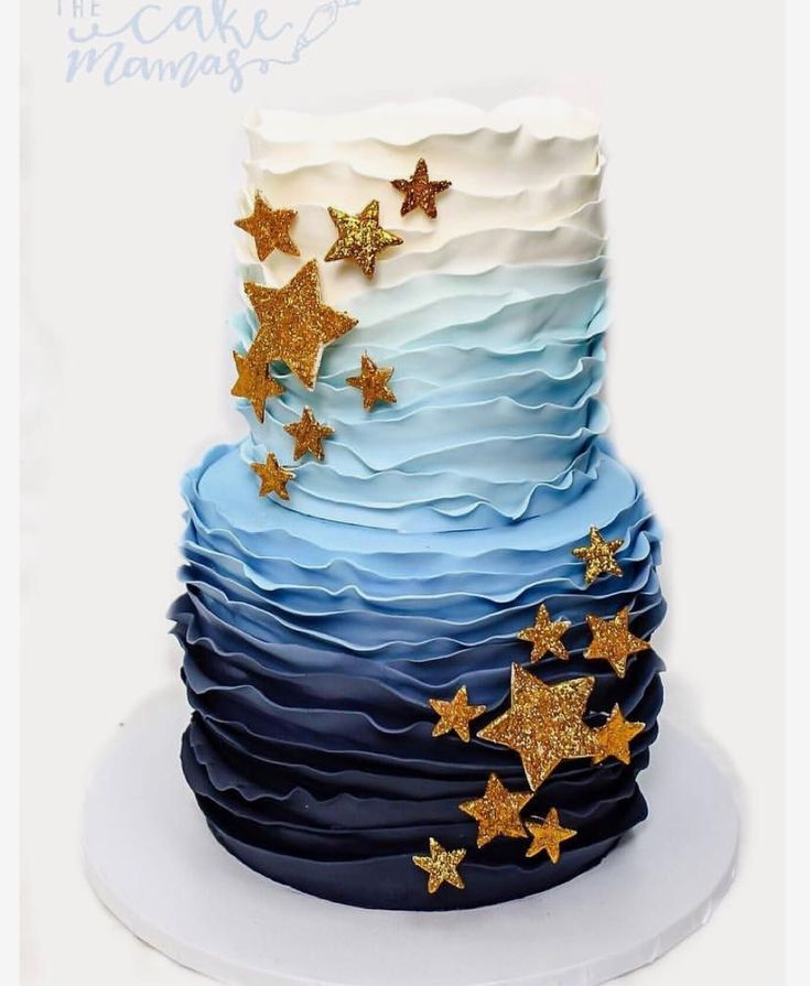 a three tiered cake with blue and white frosting, gold stars on top