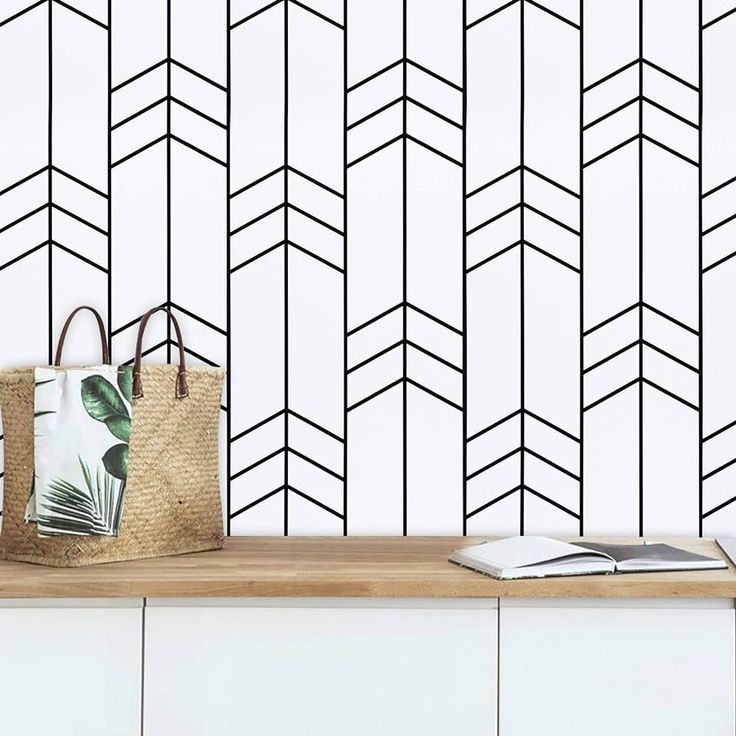 a bag sitting on top of a wooden table next to a wall with black and white lines