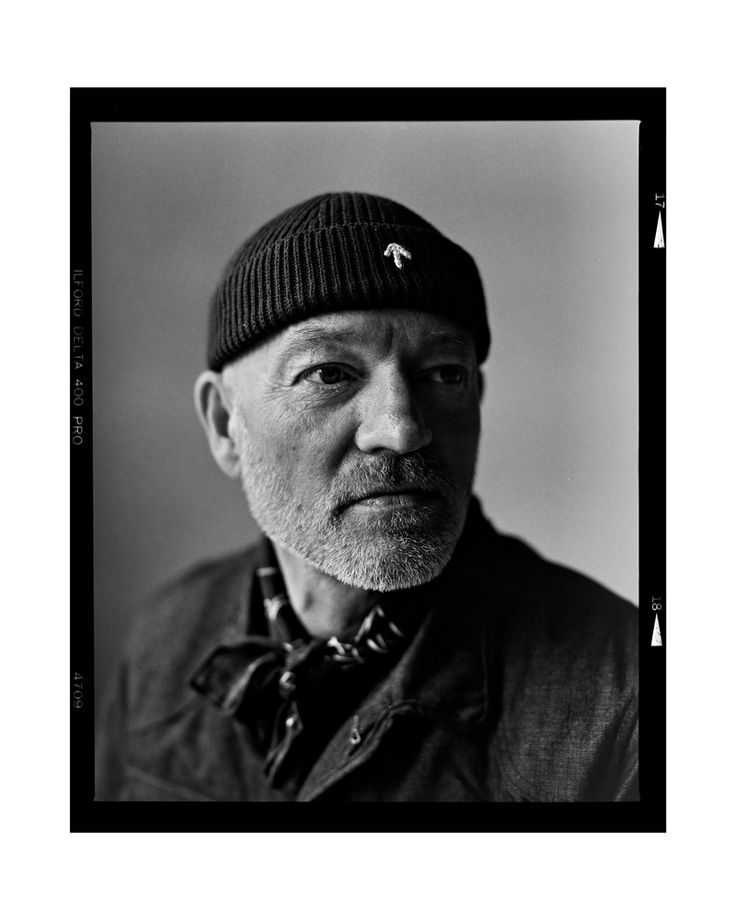 black and white photograph of an older man wearing a beanie with his eyes closed