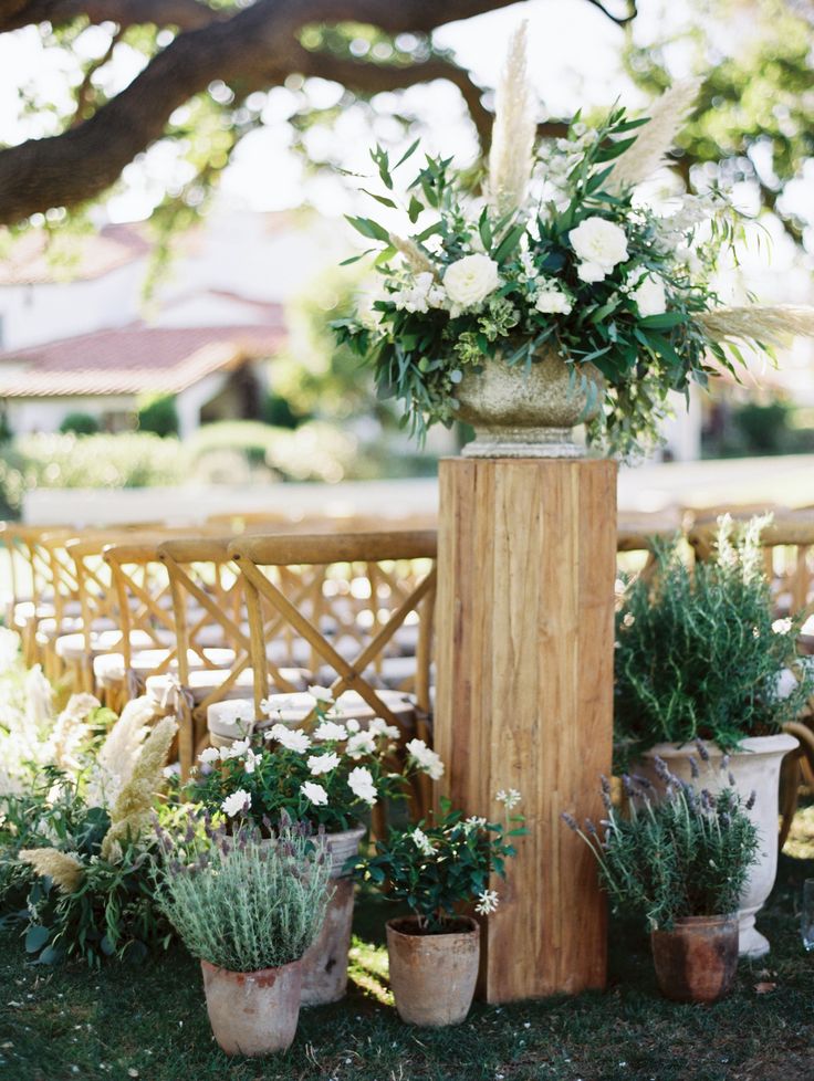 an outdoor ceremony setup with flowers and greenery