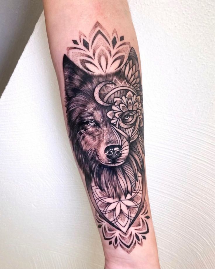 a black and white tattoo on the arm of a woman with a wolf head in it