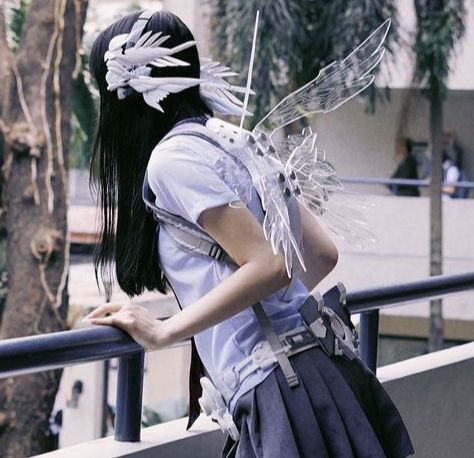 a woman with long black hair and white wings on her back is looking over a railing