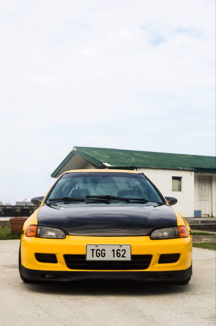 a black and yellow car parked in front of a house