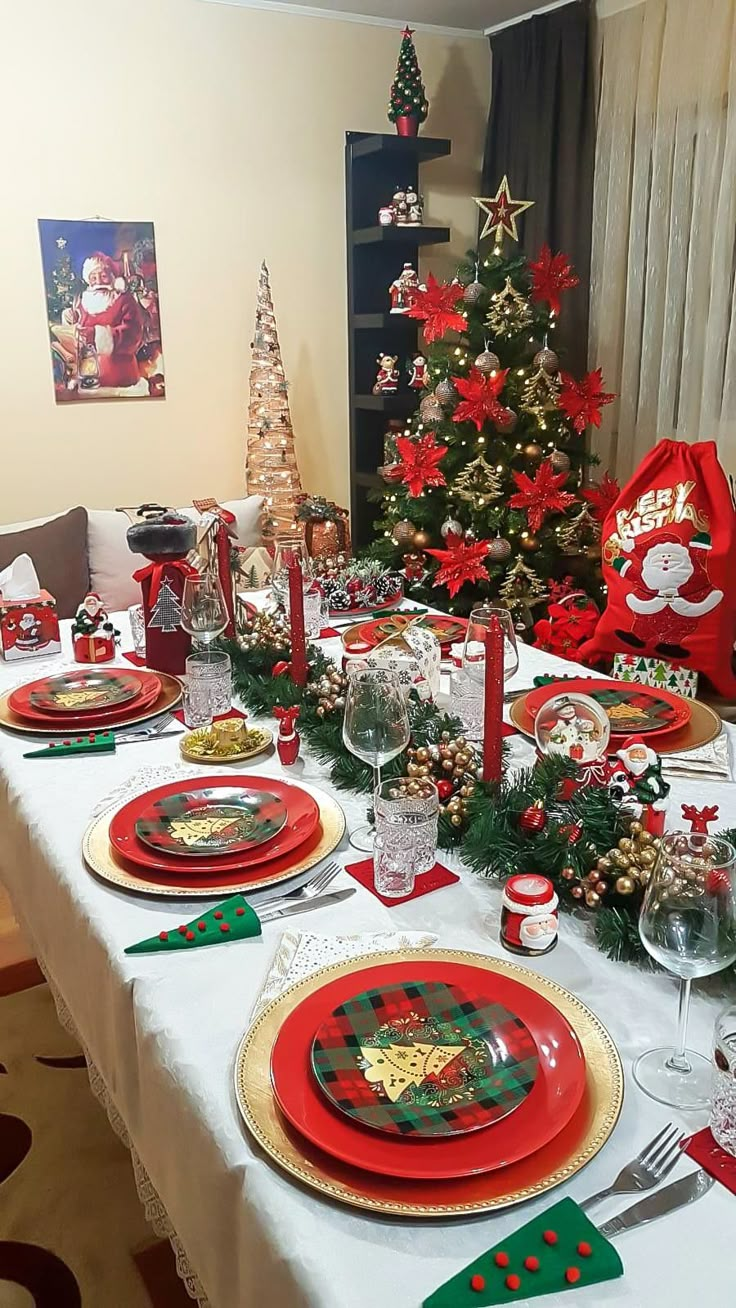 the table is set for christmas dinner with red and green plates