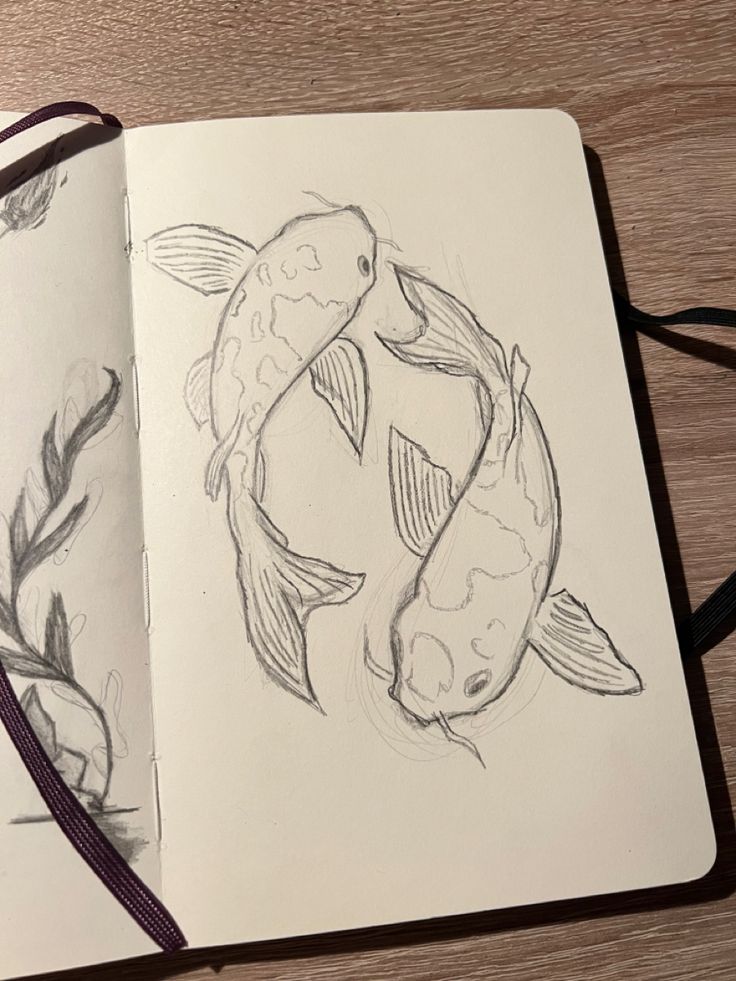 an open notebook with two drawings of fish