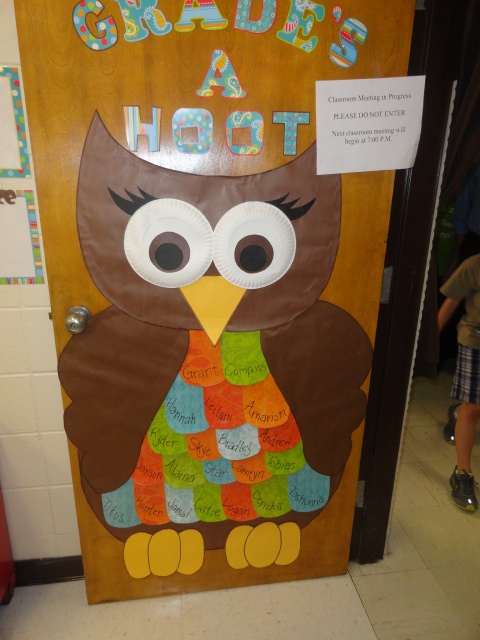 a door decorated to look like an owl with the words grad's a hoot written on it