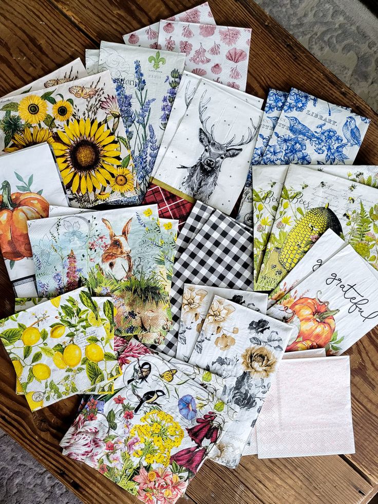 many cards are laid out on a table with flowers and animals in the middle one has a sunflower