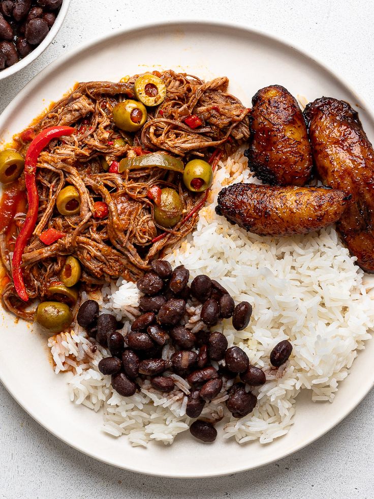 a white plate topped with rice, beans and meat