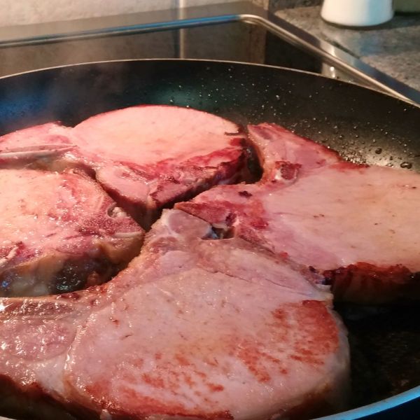 some meat is cooking in a pan on the stove