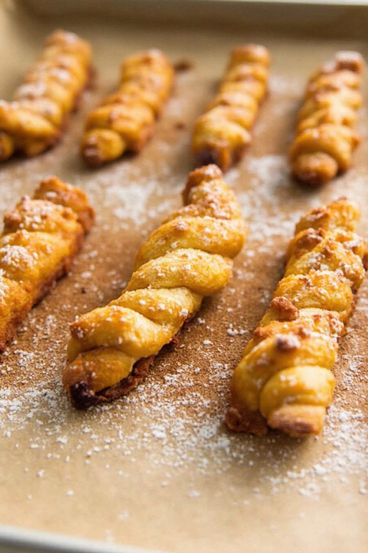 some food is laying out on a baking sheet covered in powdered sugar and sprinkled with icing