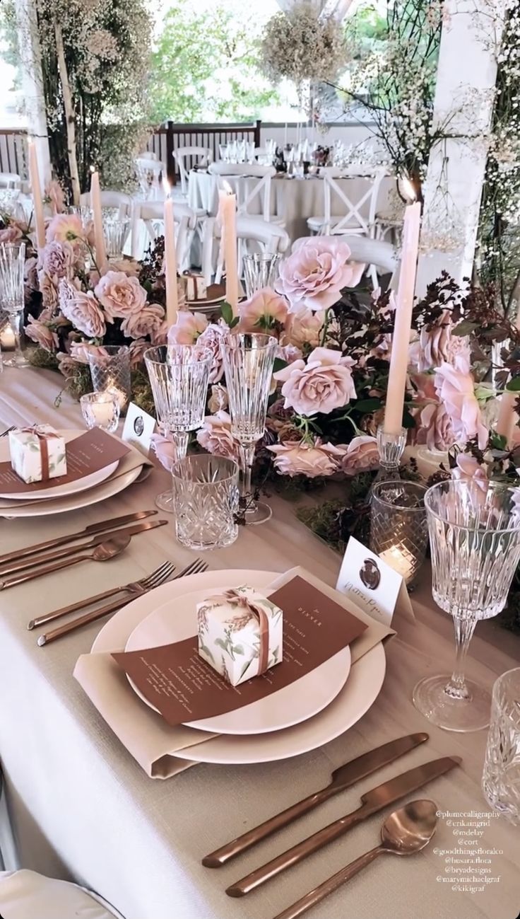 the table is set with place settings and candles