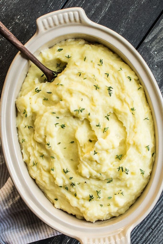 a bowl filled with mashed potatoes on top of a wooden table