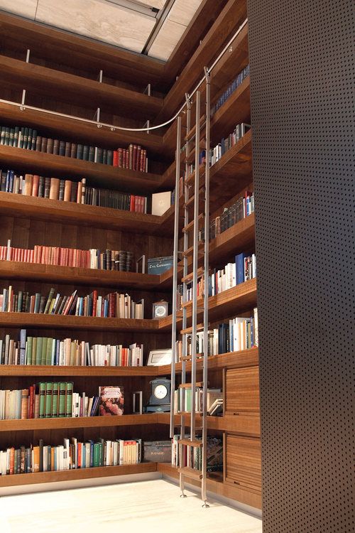 a bookshelf filled with lots of books next to a wall full of shelves