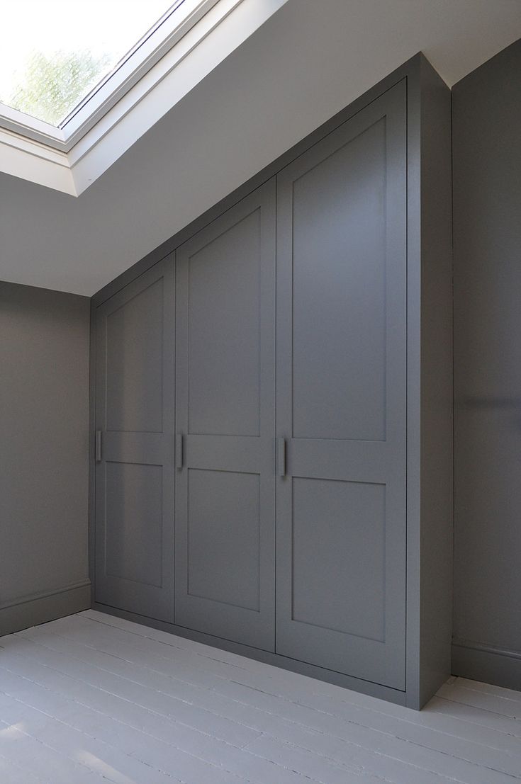 an empty room with gray cupboards and skylight