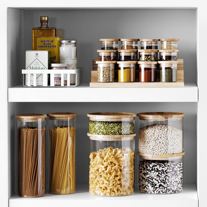 the shelves are filled with different types of pasta and other food items in glass containers