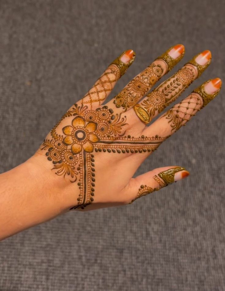 a woman's hand with henna tattoos on it