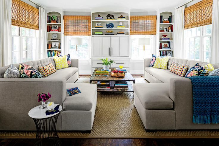 a living room filled with lots of furniture next to a window covered in bookshelves