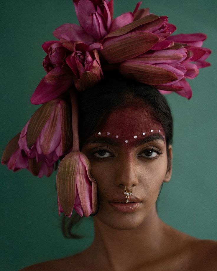 a woman with makeup and flowers on her head