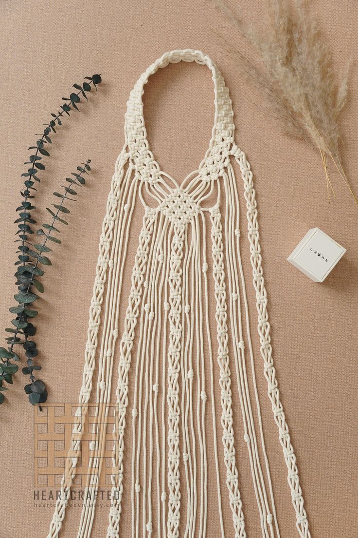 a white crocheted bag next to some dried plants