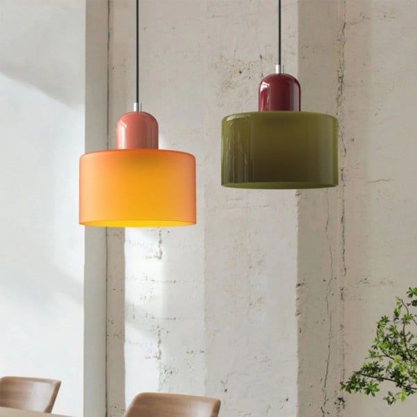 two different colored lights hanging from the ceiling in a room with chairs and table next to each other