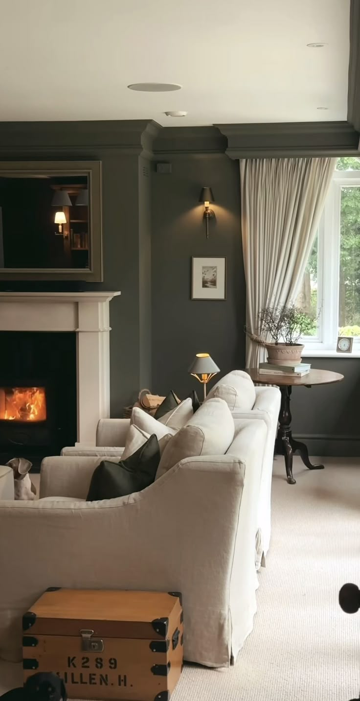 a living room filled with furniture and a fire place in the middle of the room