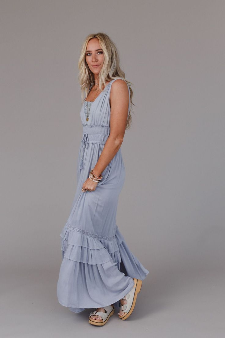 The Santa Maria Tiered Lace Maxi Dress is phenomenal, true must - have piece that no boho closet is complete without! So effortlessly boho, you can’t help but feel fabulous and confident in this dress because it features: Lightweight and flowy, woven fabric with a gorgeous, tiered, maxi silhouette Delicate lace details along the neckline and hem that adds a special touch Smocked tassel drawstring waistline creates a flattering, adjustable shape while allowing for comfortable wear all day long Li Casual V-neck Tiered Dress For Beach, Flowy Bohemian V-neck Tiered Dress, Summer V-neck Tiered Beach Dress, Spring Bohemian V-neck Tiered Dress, Blue Casual V-neck Tiered Dress, Tank Top Straps, Lace Maxi, 80 Dress, Lace Bralette