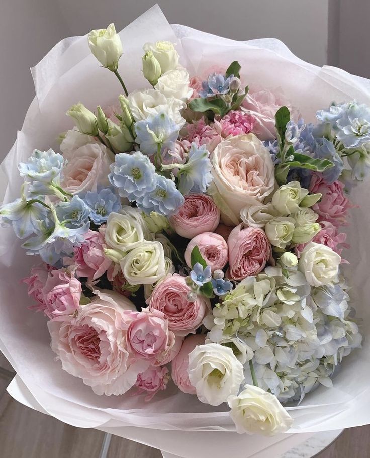 a bouquet of pink, white and blue flowers