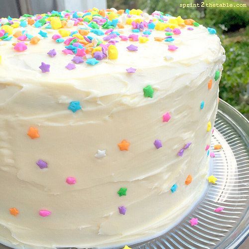 a cake with white frosting and sprinkles