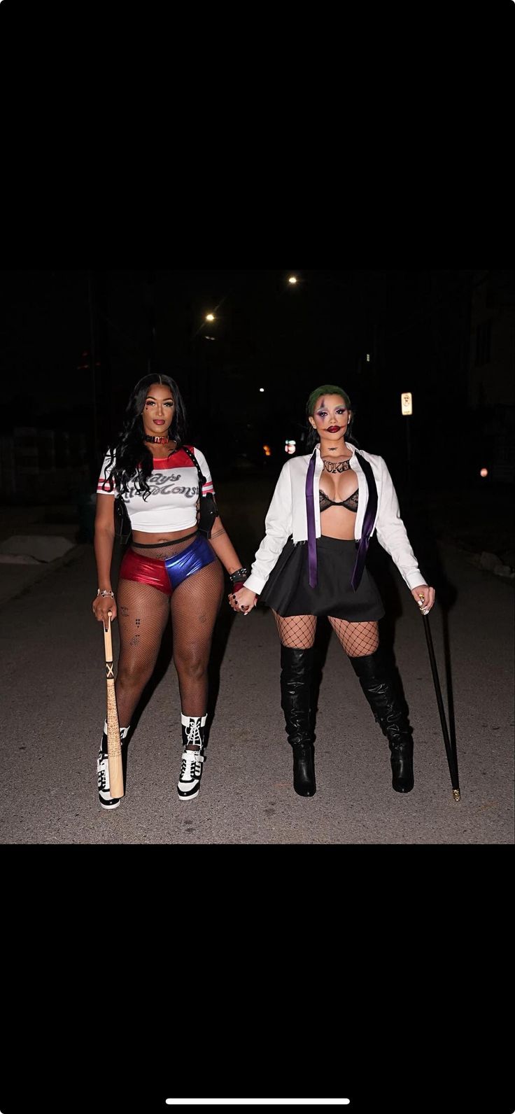 two women dressed in costumes and holding baseball bats