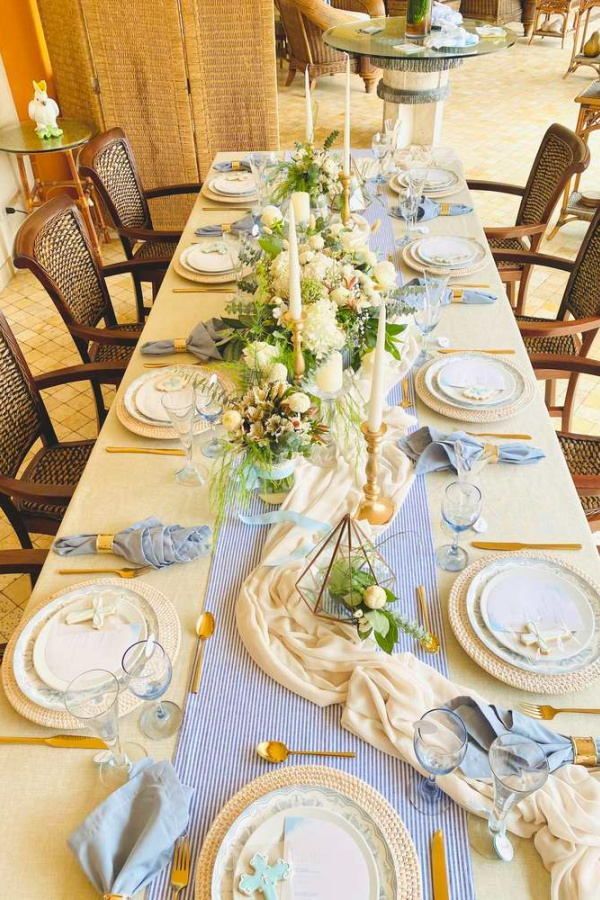 the table is set with blue and white plates, napkins, silverware, and flowers