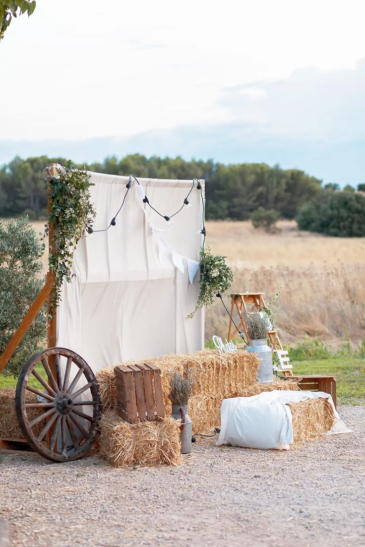 hay bales stacked on top of each other in front of a white tent