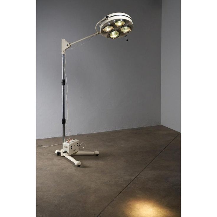 a lamp that is sitting on top of a cement floor in front of a wall