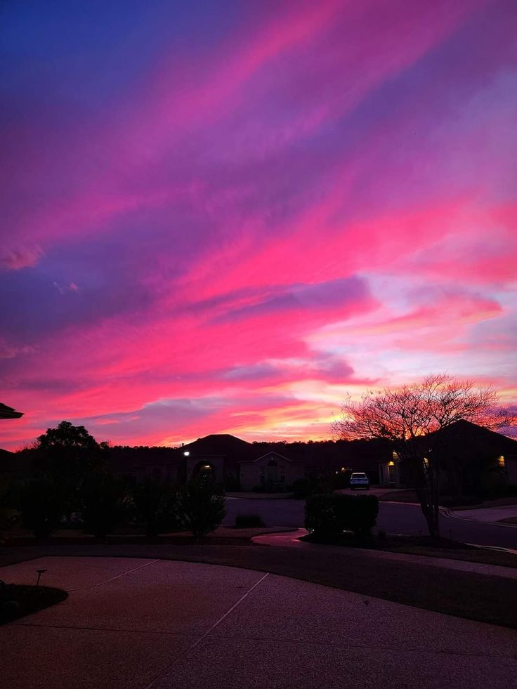 the sky is pink and purple as the sun sets