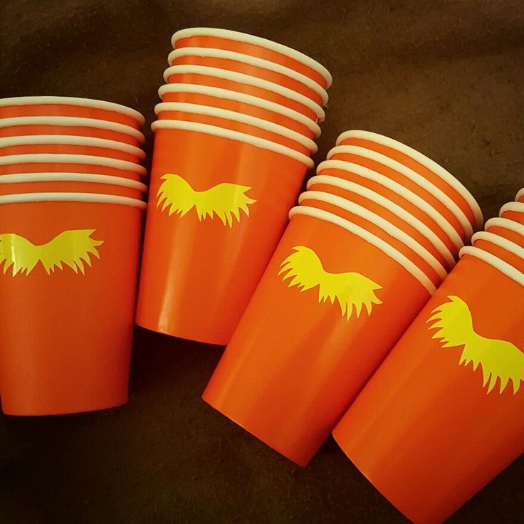 orange cups with yellow dog on them sitting next to each other in front of a black background