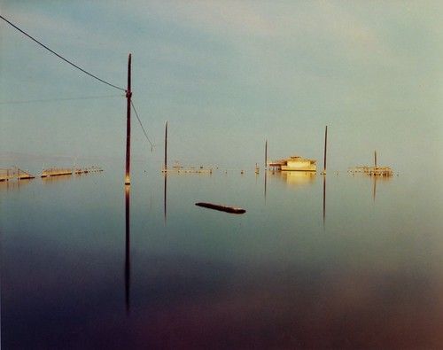 there are many boats in the water and one boat is floating on it's side