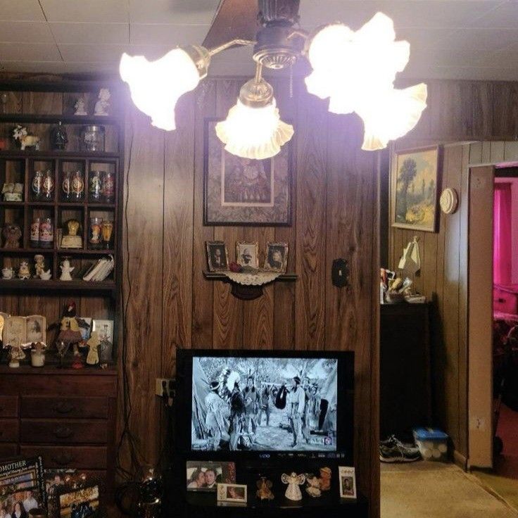 a living room filled with furniture and a flat screen tv sitting on top of a wooden table