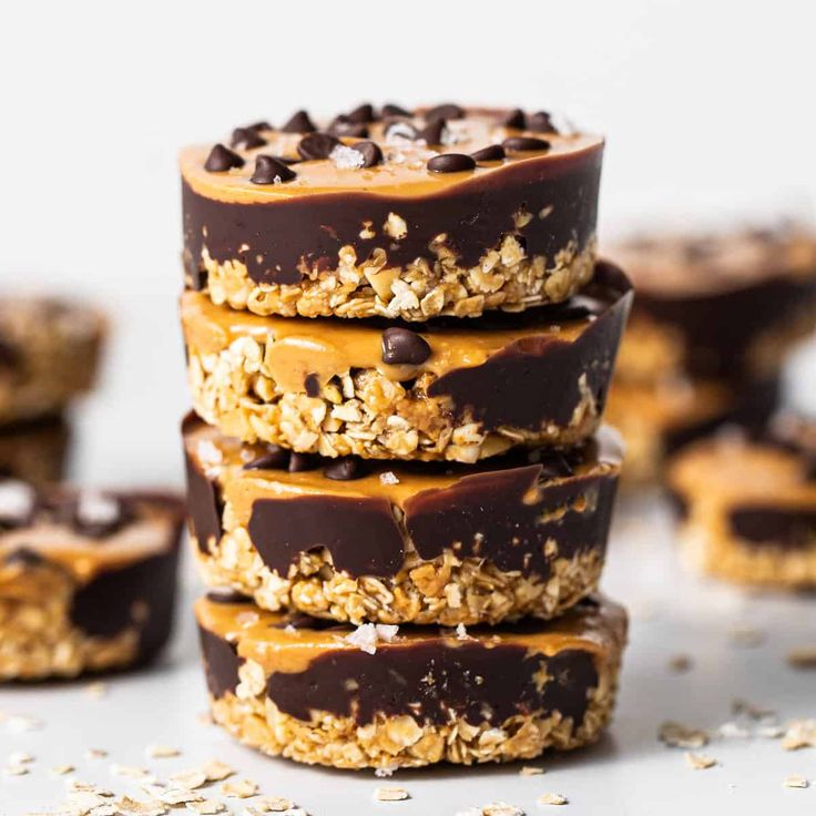 chocolate covered cookies stacked on top of each other with oats and peanut butter in the middle