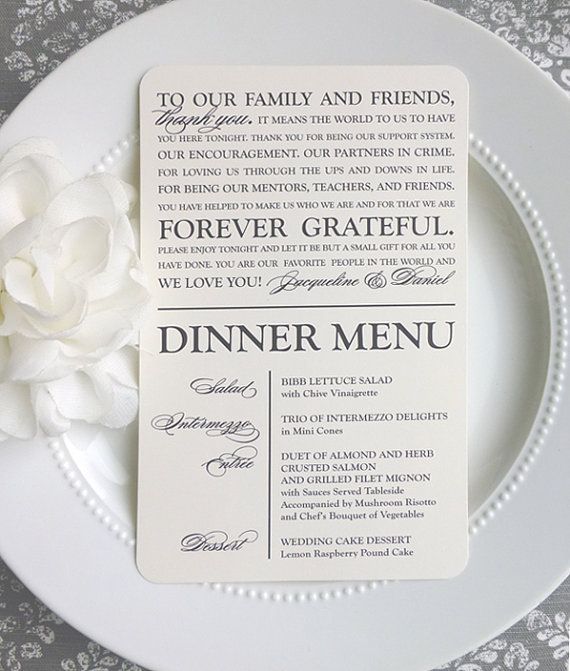 a white plate topped with a dinner menu next to a flower on top of it