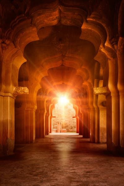 the light shines brightly through an archway in a building with columns and arches on both sides