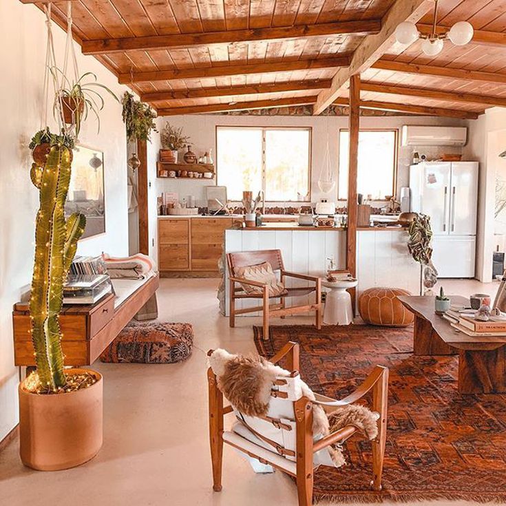 a living room filled with furniture next to a kitchen and dining room table covered in potted plants