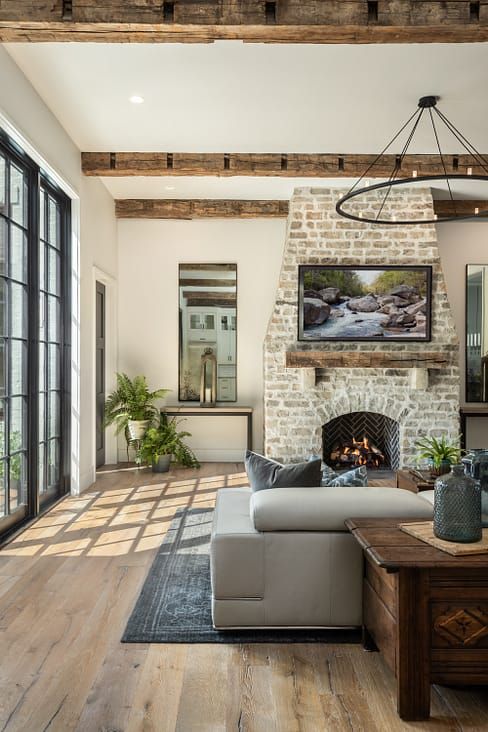 a living room with a fireplace and large windows