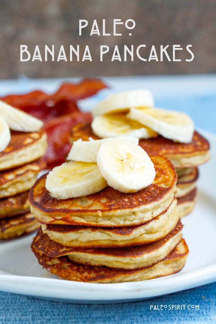 pancakes with banana slices and bacon on a white plate, sitting on a blue tablecloth