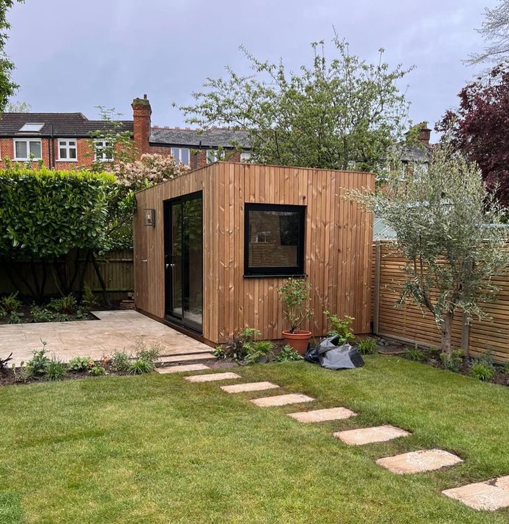 a small wooden shed in the middle of a yard with steps leading up to it