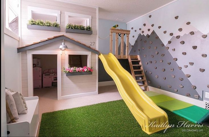 a child's playroom with a slide, climbing wall and flower boxes on the walls